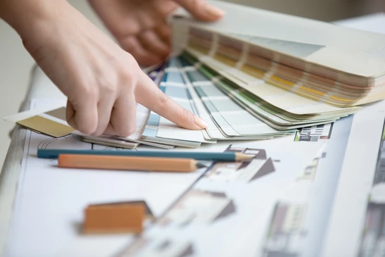 Deux professionnels examinent un nuancier textile sur table basse dans salon moderne