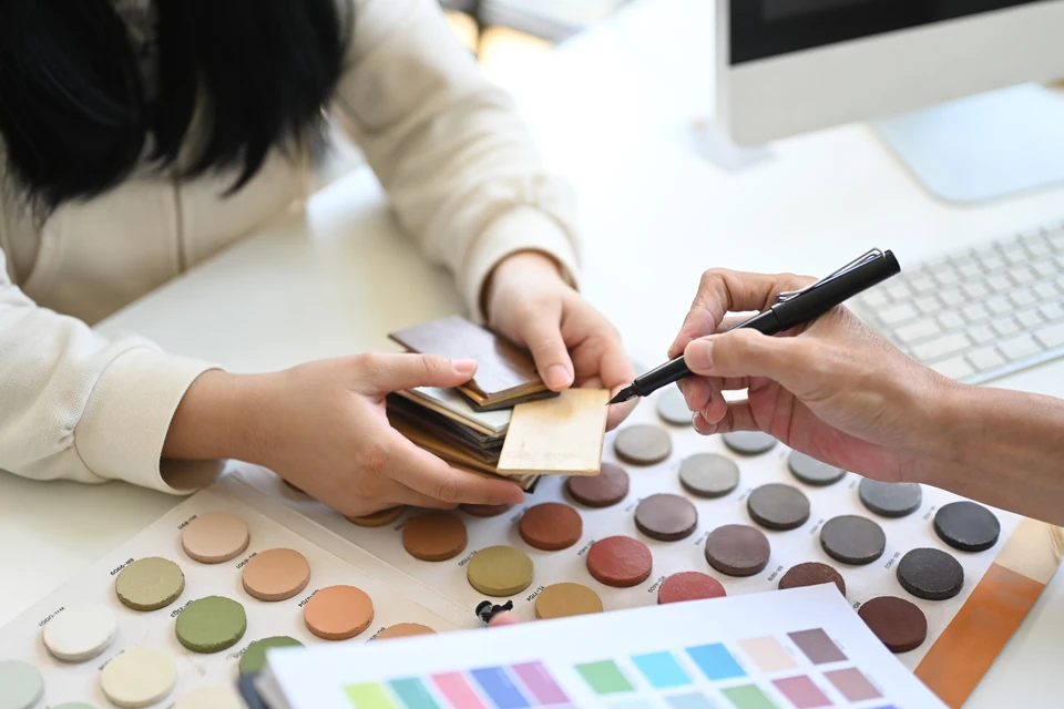 Scène d'intérieur avec une femme consultant des nuanciers de couleurs sur une table